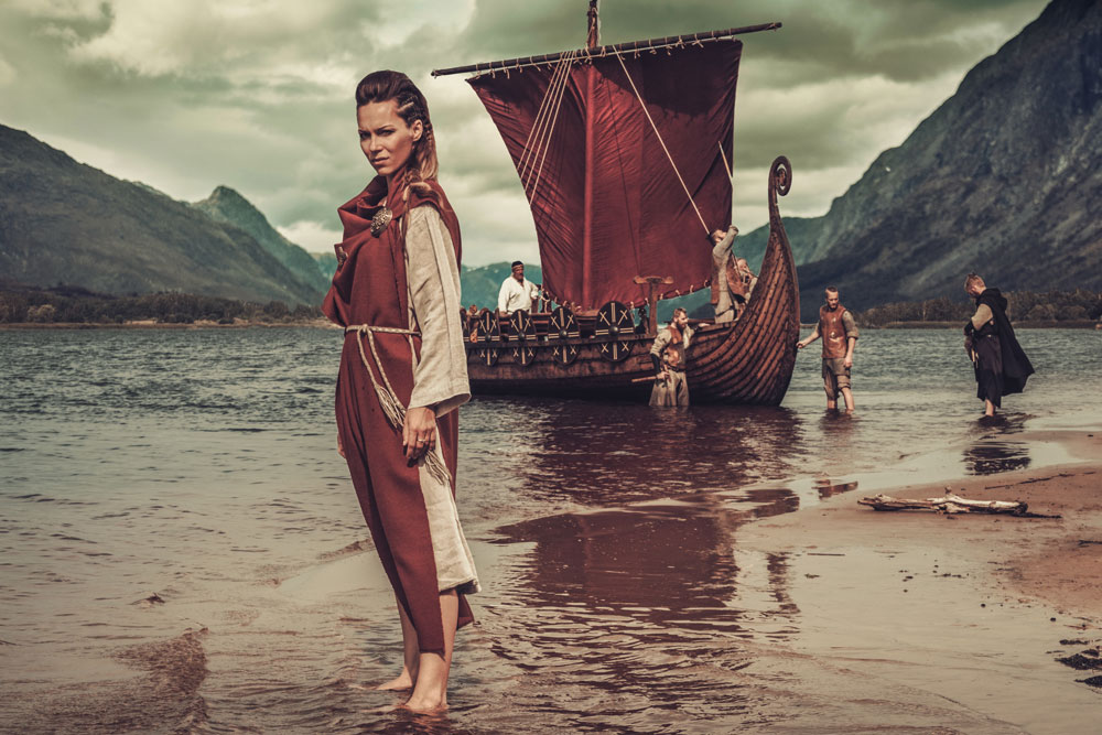 viking-woman-standing-near-drakkar-on-seashore-2021-08-26-16-21-13-utc